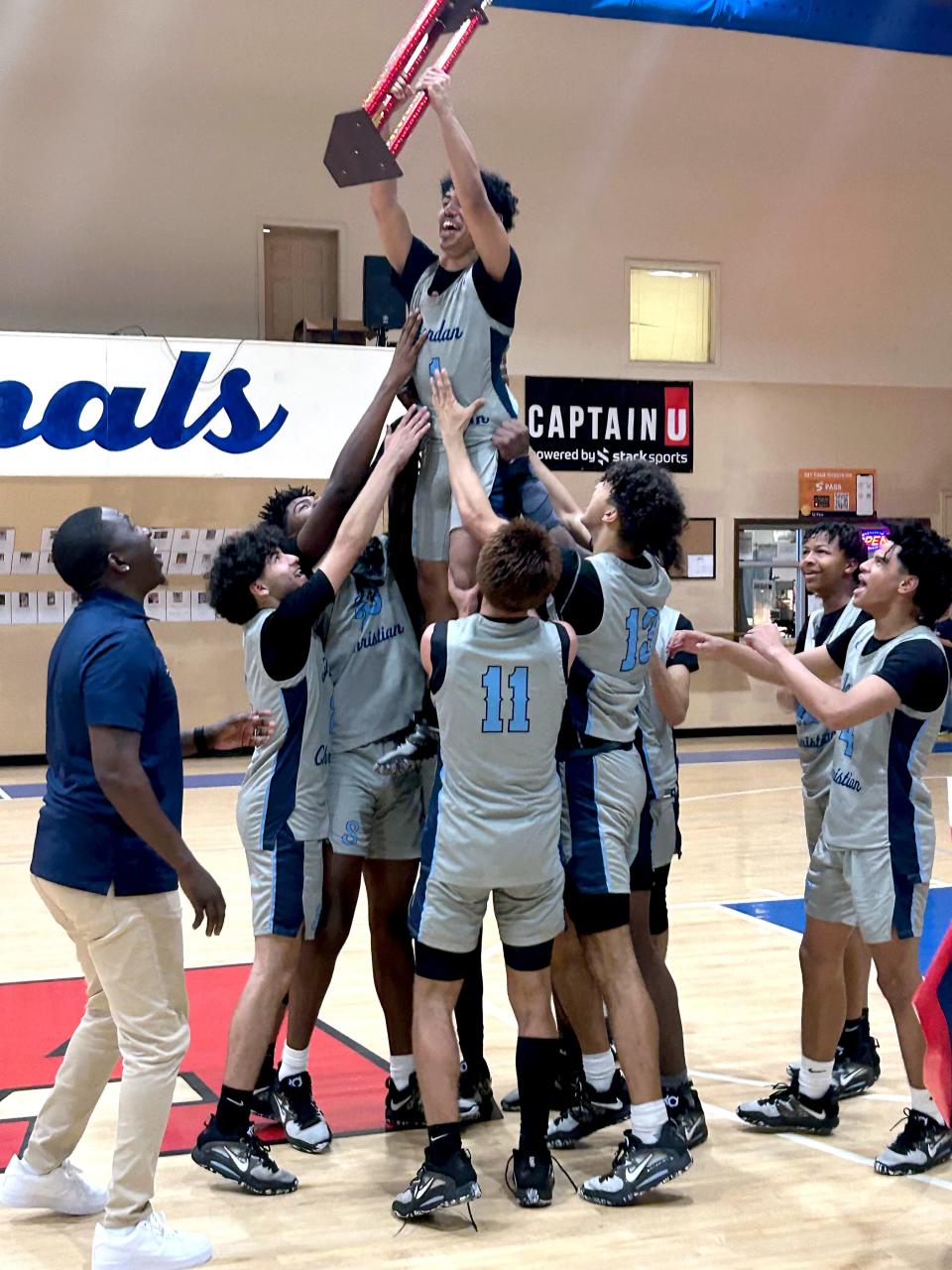 Jordan Christian Prep's Gary Nevarez is lifted in the air with the trophy by his teammates as they celebration winning the NACA Division 5 national tournament.