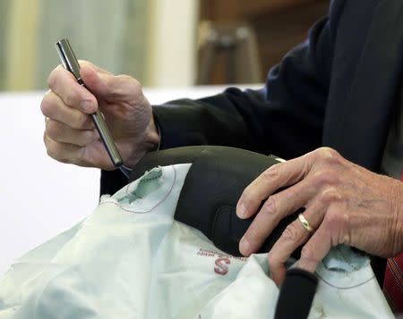 Senator Bill Nelson (D-FL) displays shrapnel holes of a Honda steering wheel airbag, made by Takata, before chairing a Senate Commerce, Science and Transportation Committee hearing on "Examining Takata Airbag Defects and the Vehicle Recall Process." in Washington November 20, 2014. REUTERS/Gary Cameron