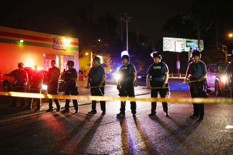 FERGUSON, MO - AUGUST 11:  Police lock down a neighborhood on August 11, 2014 in Ferguson, Missouri. Police responded with tear gas as residents and their supporters protested the shooting by police of an unarmed black teenager named Michael Brown who was killed Saturday in this suburban St. Louis community. Yesterday 32 arrests were made after protests turned into rioting and looting in Ferguson.   (Photo by Scott Olson/Getty Images)