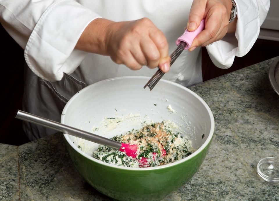 Add filling ingredients to the spinach and grate a touch of nutmeg to lift the flavors.
