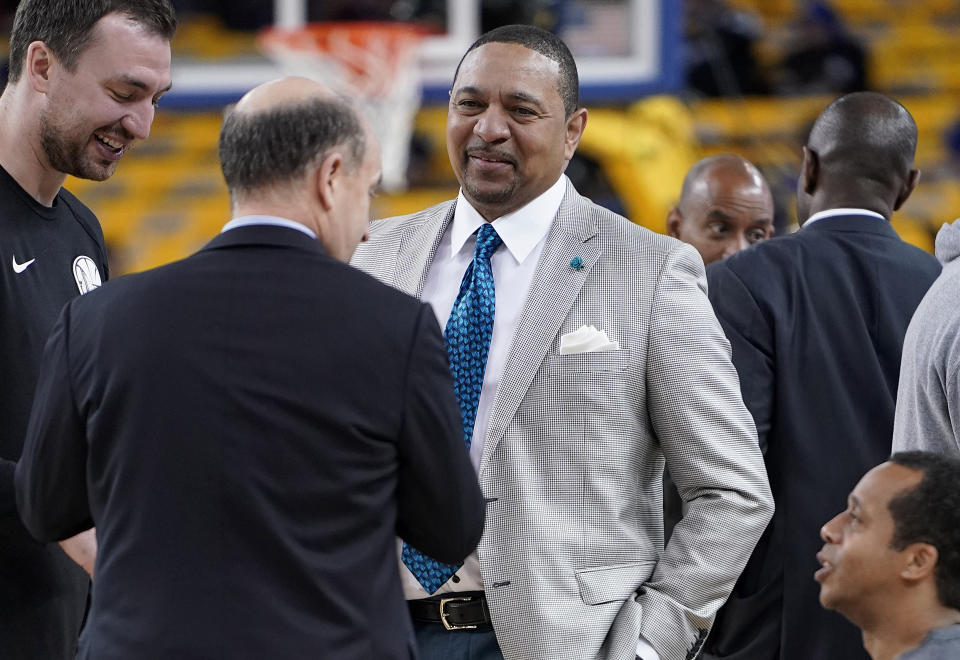 Mark Jackson, center, talks with Jeff Van Gundy, second from left, and others before Game 4 of basketball's NBA Finals between the Golden State Warriors and the Toronto Raptors in Oakland, Calif., Friday, June 7, 2019. ABC/ESPN NBA analyst Jackson credits faith, confidence and longtime friendships with Van Gundy and Mike Breen as the main catalysts for his longevity and why he is working his 12th NBA Finals. (AP Photo/Tony Avelar)