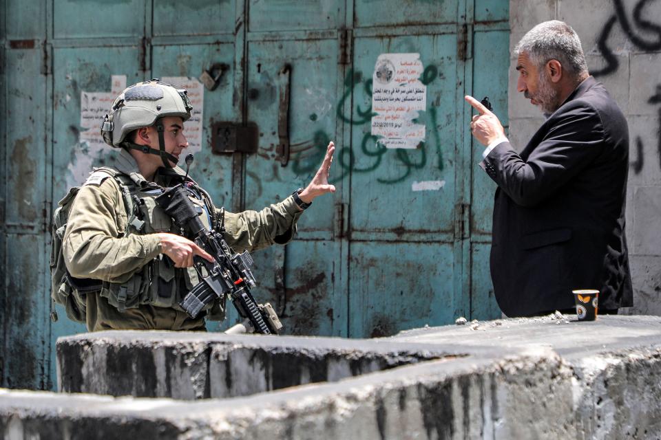 A Palestinian man argues with an Israeli soldier in the center of Hebron in the occupied West Bank on July 4, 2023.