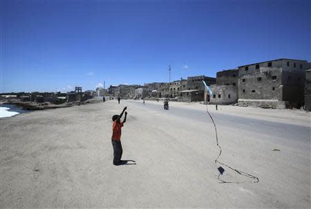 A boy plays with a kite in front of his home in the Hamaerweyne area of Mogadishu October 12, 2013. REUTERS/Feisal Omar