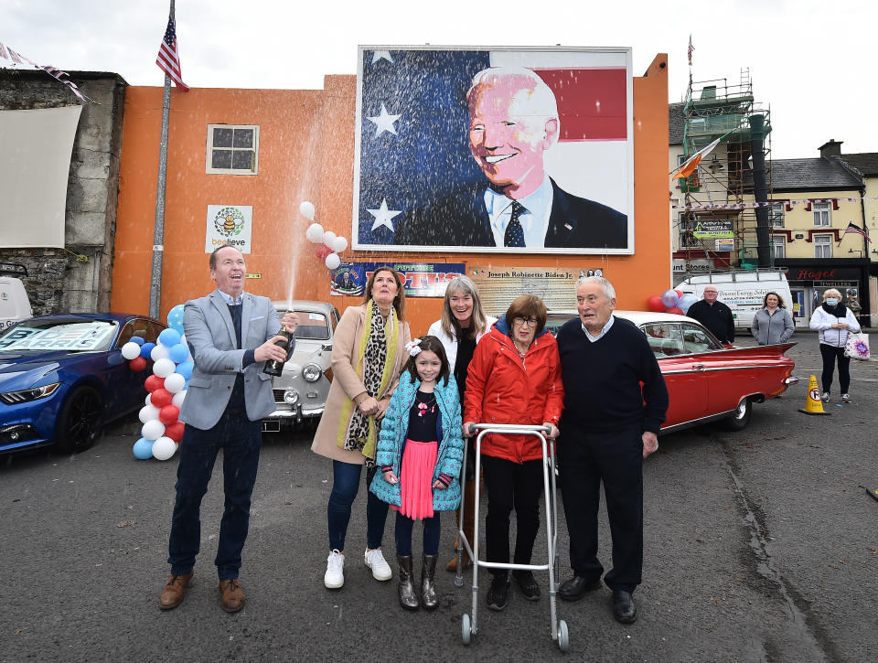 Joe Blewitt a cousin of Joe Biden sprays a bottle of champagne along with family members underneath a mural of Presidential candidate Joe Biden as locals celebrate (Nov. 7) in anticipation of Biden being elected as the next US President in Ballina, Ireland. Joe Biden whose distant relatives hail from the County Mayo town of Ballina has visited the town twice before as the former Vice President. Photo: Charles McQuillan/Getty Images