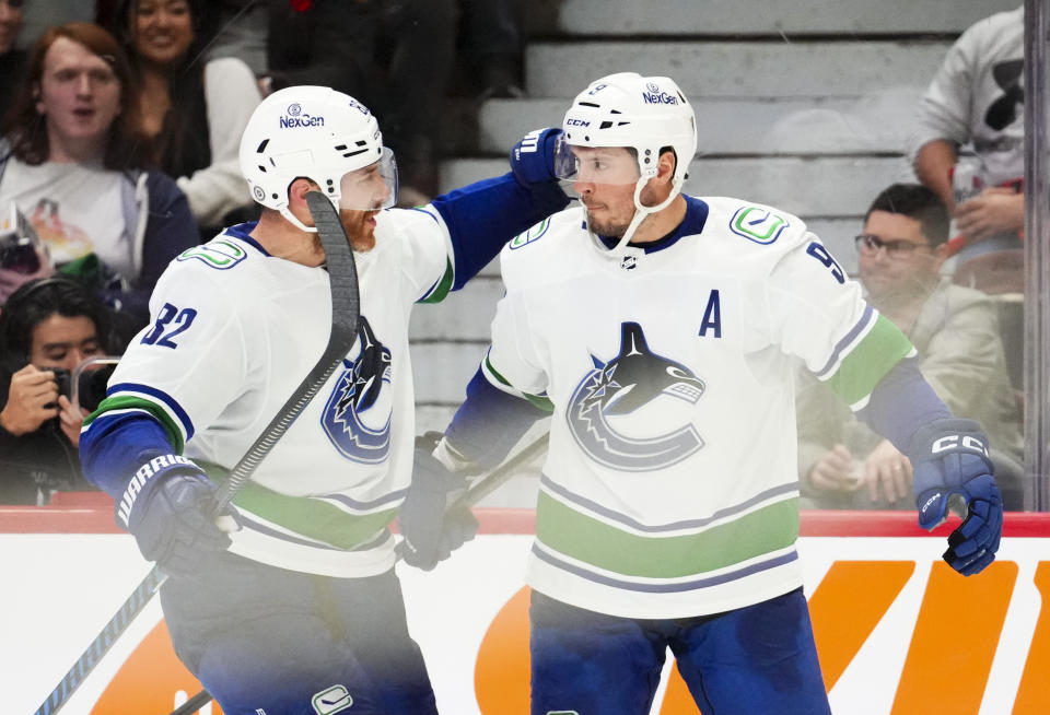 Vancouver Canucks defenseman Ian Cole, left, congratulates center J.T. Miller (9) on his goal against the Ottawa Senators during second-period NHL hockey game action in Ottawa, Ontario, Thursday, Nov. 9, 2023. (Sean Kilpatrick/The Canadian Press via AP)