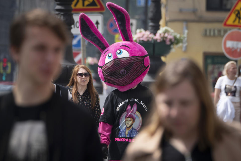 A person dressed as a bunny and wearing a funny face mask advertises a store amid the ongoing COVID-19 pandemic in St. Petersburg, Russia, Wednesday, June 10, 2020. (AP Photo/Dmitri Lovetsky)