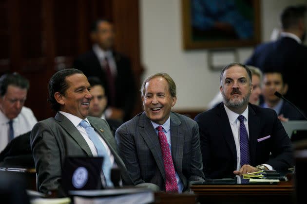 Ken Paxton, center, sits between defense attorneys Tony Buzbee, left, and Mitch Little, right, during a break in trial proceedings Friday.