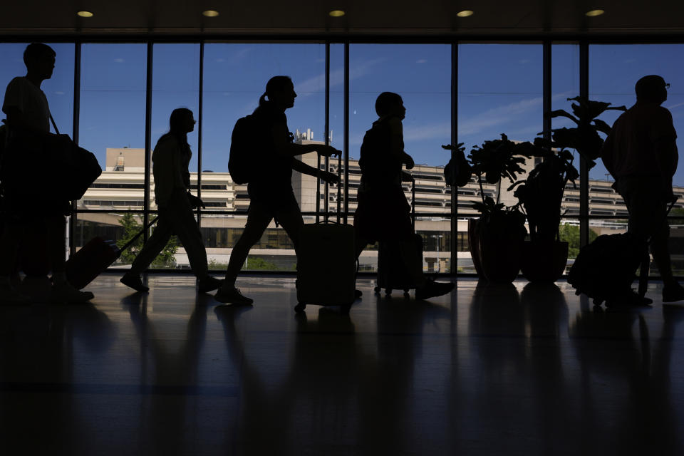 Travelers walk through the Philadelphia International Airport, Wednesday, July 3, 2024, in Philadelphia. (AP Photo/Matt Slocum)