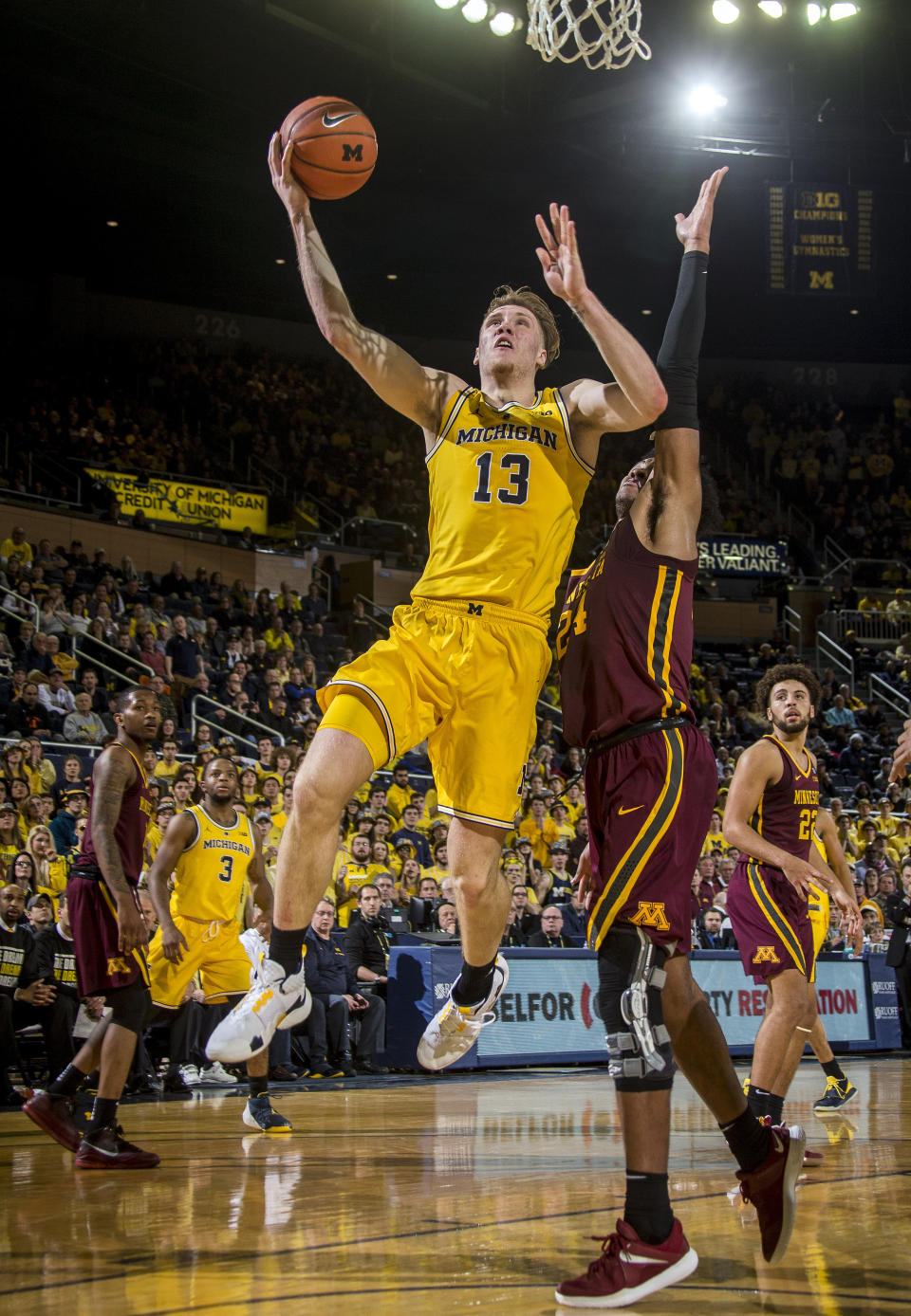 Michigan forward Ignas Brazdeikis (13) goes to the basket, defended by Minnesota forward Eric Curry (24), in the second half of an NCAA college basketball game at Crisler Center in Ann Arbor, Mich., Tuesday, Jan. 22, 2019. Michigan won 59-57. (AP Photo/Tony Ding)
