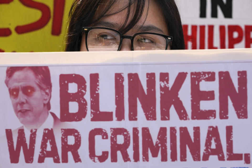 A protester holds a slogan against the visit of U.S. Secretary of State Antony Blinken during a rally near the Malacanang presidential palace in Manila, Philippines on Tuesday, March 19, 2024. (AP Photo/Aaron Favila)