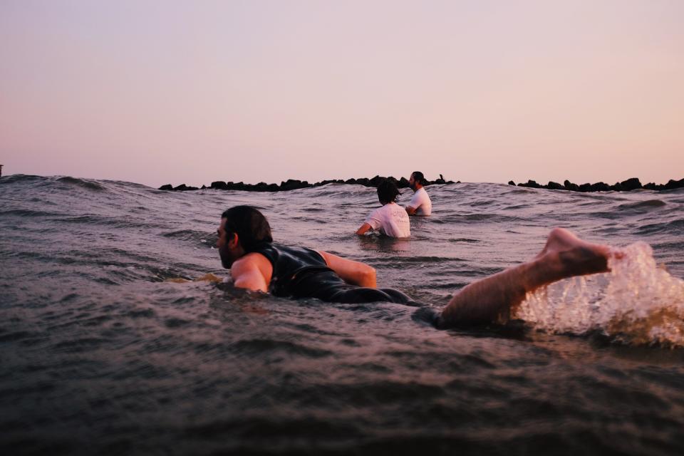 Surfers in Grand Isle catch waves as the sun rises