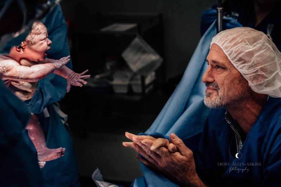 An emotional father is handed his baby for the first time