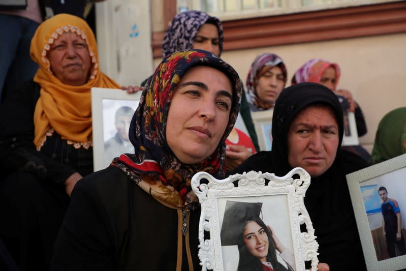 Mothers hold pictures of their children who joined the PKK militant group, during a sit-in protest outside the local headquarters of Pro-Kurdish HDP in Diyarbakir