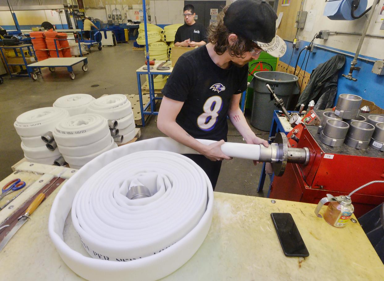 Employee Ted Sheaffer, 30, attaches couplings to hose sections at Snap-Tite Hose in Fairview Township on Nov. 3.