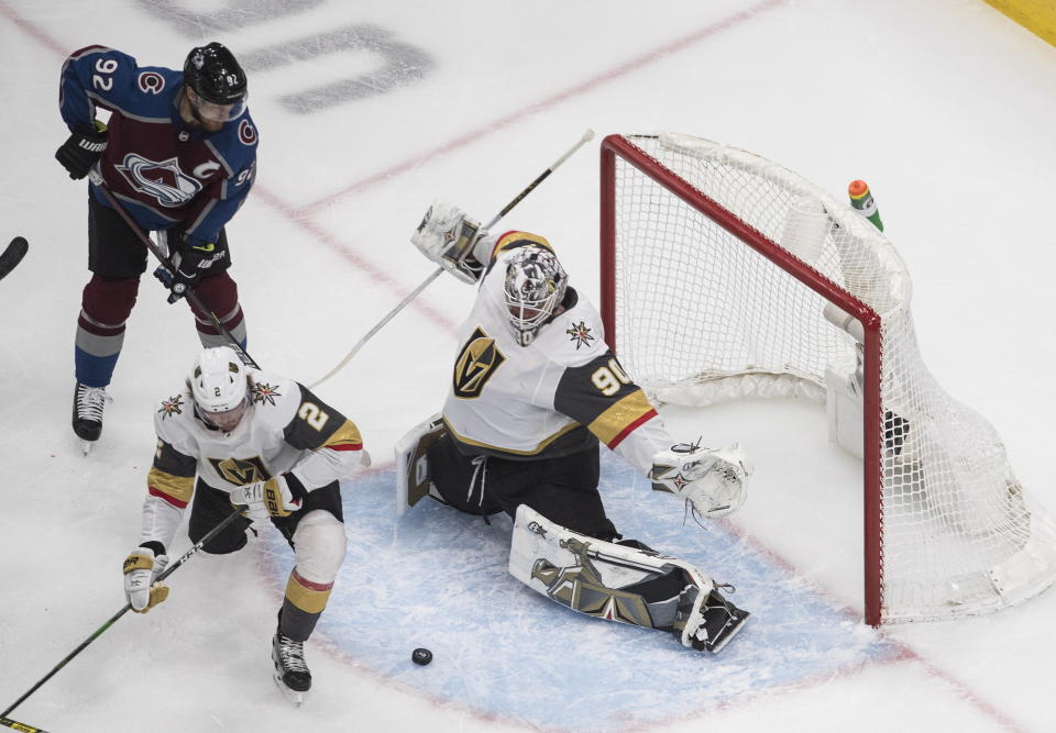 Colorado Avalanche's Gabriel Landeskog (92) and Vegas Golden Knights' Zach Whitecloud (2) look for the rebound on the save from goalie Robin Lehner (90) during the second period of an NHL Stanley Cup hockey qualifying round game in Edmonton, Alberta, Saturday, Aug. 8, 2020.(Jason Franson/The Canadian Press via AP)