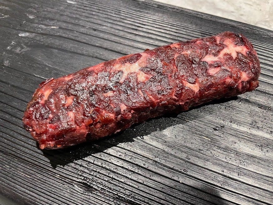 Unwrapped cranberry chevre on a black cutting board