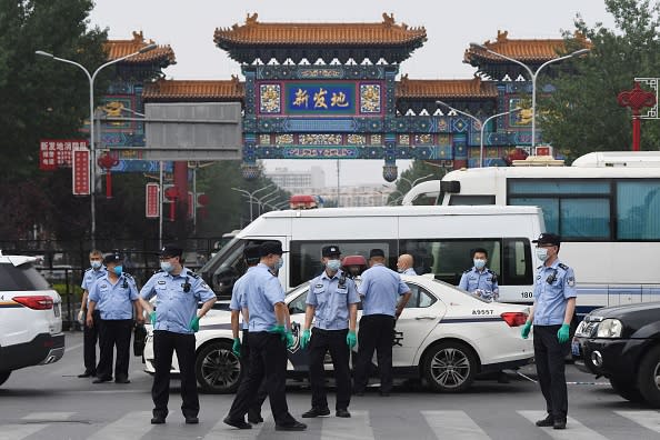 Chinese police guard the entrance to the closed Xinfadi market in Beijing.