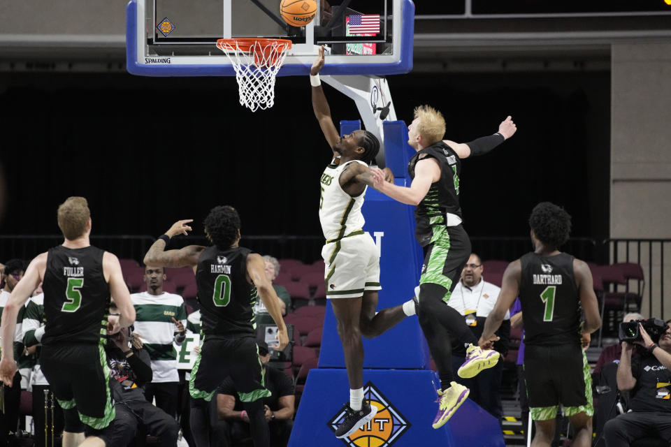UAB's Ty Brewer (15) shoots around Utah Valley's Trey Woodbury (4) during the second half of an NCAA college basketball game in the semifinals of the NIT, Tuesday, March 28, 2023, in Las Vegas. (AP Photo/John Locher)