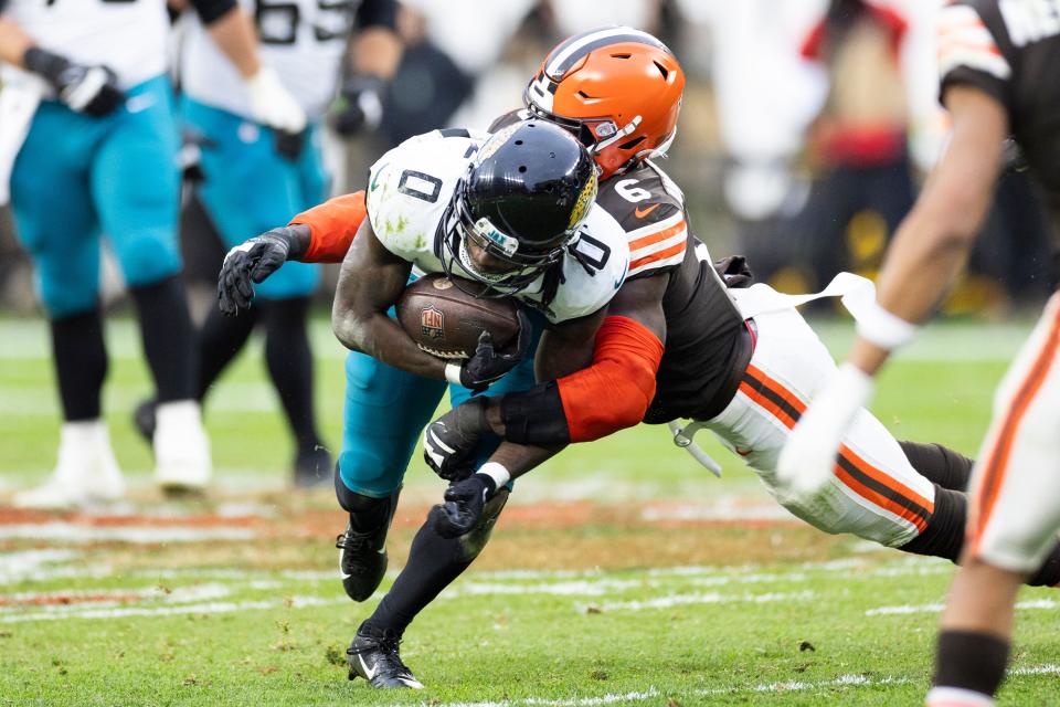 Dec 10, 2023; Cleveland, Ohio, USA; Jacksonville Jaguars wide receiver Calvin Ridley (0) gets tackled by Cleveland Browns linebacker Jeremiah Owusu-Koramoah (6) while running the ball during the fourth quarter at Cleveland Browns Stadium. Mandatory Credit: Scott Galvin-USA TODAY Sports