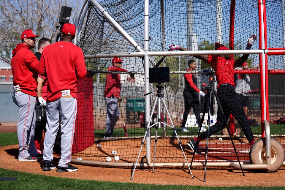 Cincinnati Reds hitting coach Joel McKeithan, far left, observes Cincinnati Reds shortstop Elly De La Cruz (44) take live batting practice during spring training workouts, Thursday, Feb. 15, 2024, at the team’s spring training facility in Goodyear, Ariz.