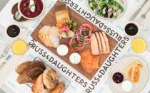 <p>No one understands the fine art of smoked fish quite like the folks at <a rel="nofollow noopener" href="http://www.travelandleisure.com/travel-guide/new-york-city/shopping/russ-daughters" target="_blank" data-ylk="slk:Russ & Daughters;elm:context_link;itc:0;sec:content-canvas" class="link ">Russ & Daughters</a>, who after 100 years of business in NYC, opened a full service sit down cafe with a full bar. There you’ll find plenty of egg dishes and salads to order, but the real stars of the show are the fish platters, meant to be enjoyed communally and split between three or four people. Throw caution to the wind and order The Anne ($90), loaded up with Western Nova smoked salmon, sturgeon, sable, smoked trout, and wild Alaskan salmon roe, plus a bread basket and all the fixings. Be sure to order a zippy breakfast martini, too, made with Beefeater Gin, jam, lemon juice, egg white, Pernod Absinthe, and Angostura bitters. Consider it the ideal hangover helper.</p>