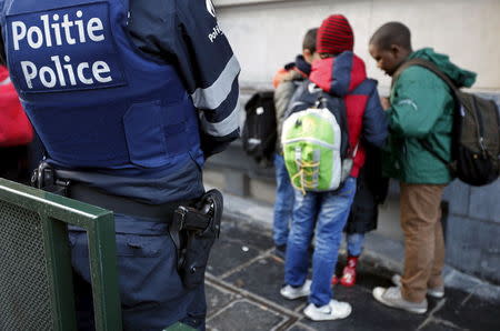 A Belgian police officer stands guard outside a school in central Brussels November 25, 2015. REUTERS/Francois Lenoir