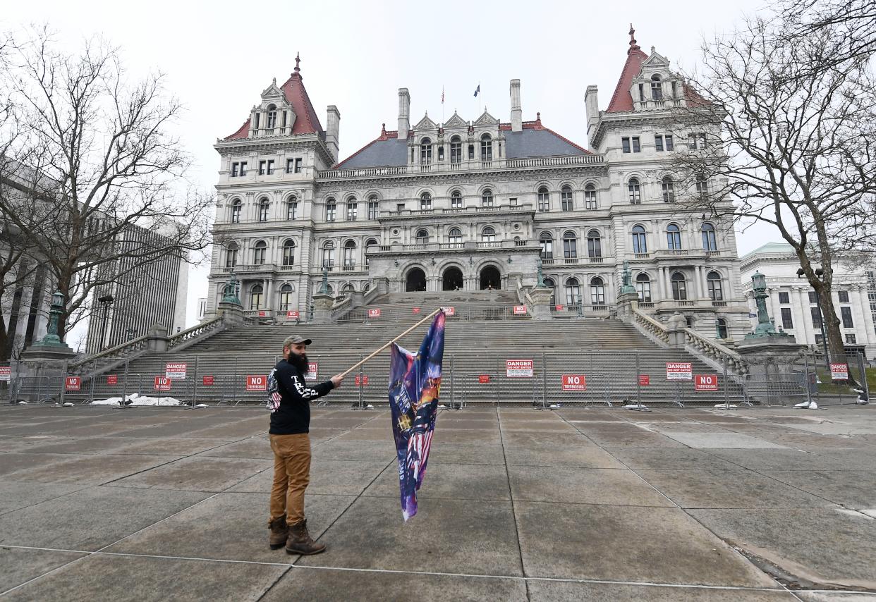 <p>Trump supporter Mark Leggiero, of Florida, N.Y., holds a banner outside the New York state Capitol objecting the inauguration of President Joe Biden on Wednesday 20 January 2021, in Albany, N.Y</p> ((Associated Press))