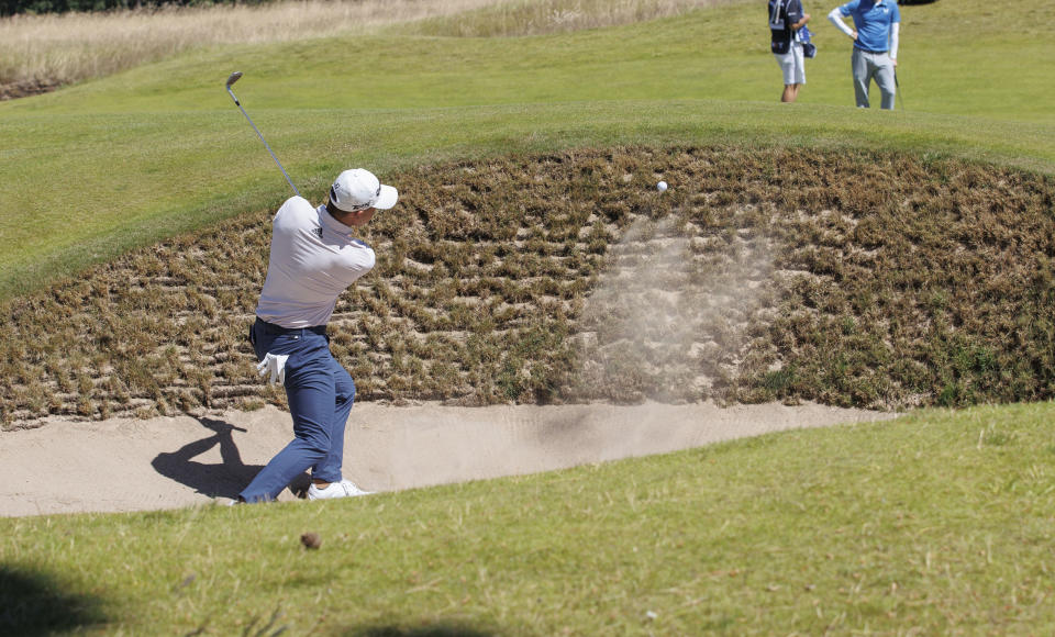 Colin Morikawa from the US plays out of the bunker on the 1st hole during day one of the Scottish Open at The Renaissance Club, North Berwick, Scotland, Thursday July 7, 2022. (Steve Welsh/PA via AP)