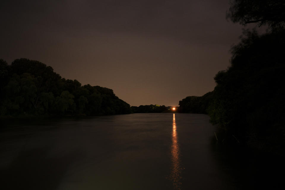 Lights shine at night on the Tisza River near Tiszaroff, Hungary, Tuesday, Aug. 1, 2023. Since its start in 2013, participants in the annual Plastic Cup competition — which offers a prize for those who collect the most trash each year — have gathered more than 330 tons (around 727,000 pounds) of waste from the Tisza and other Hungarian waters. (AP Photo/Denes Erdos)