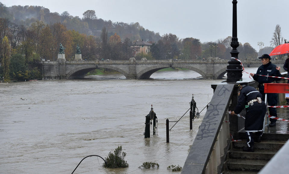 Municipality police seal off a stairway leading to the river banks as the water levels of the river Po rise, in the Murazzi area of Turin, northern Italy, Sunday, Nov. 24, 2019. Heavy rains and bad weather have been hitting most of Italy, causing river areas to flood and isolate hamlets in most part of northern Italy. (Alessandro Di Marco/ANSA via AP)