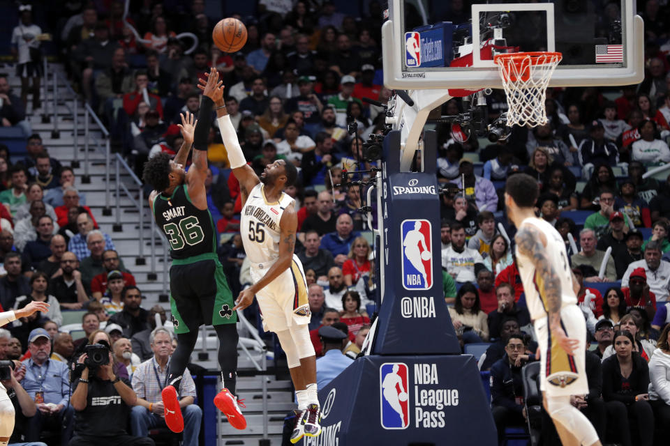 Boston Celtics guard Marcus Smart (36) shoots against New Orleans Pelicans guard E'Twaun Moore (55) in the first half of an NBA basketball game in New Orleans, Sunday, Jan. 26, 2020. (AP Photo/Gerald Herbert)