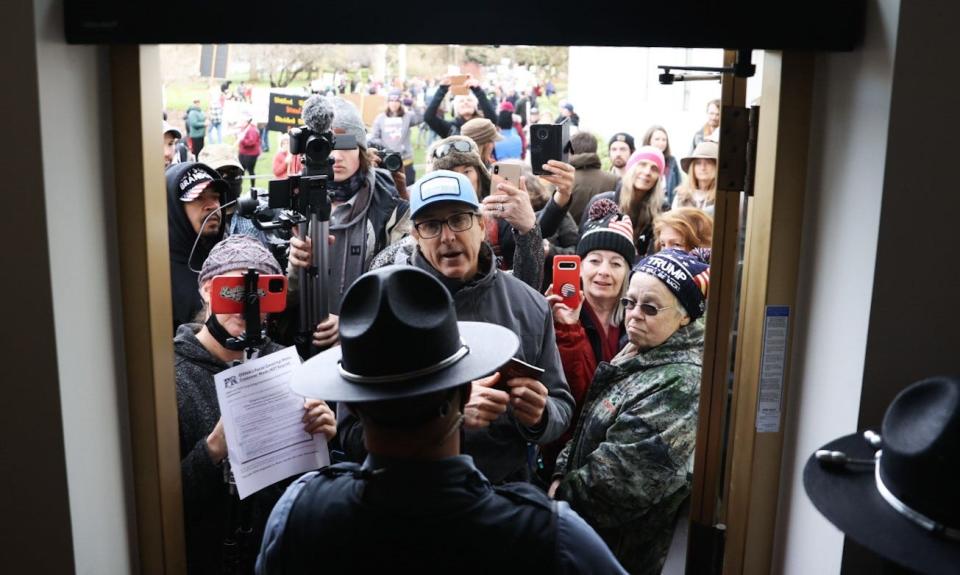 Protesters are confronted by Oregon State Police after refusing to put on masks to enter the state Capitol for the first day of the legislative session Tuesday.