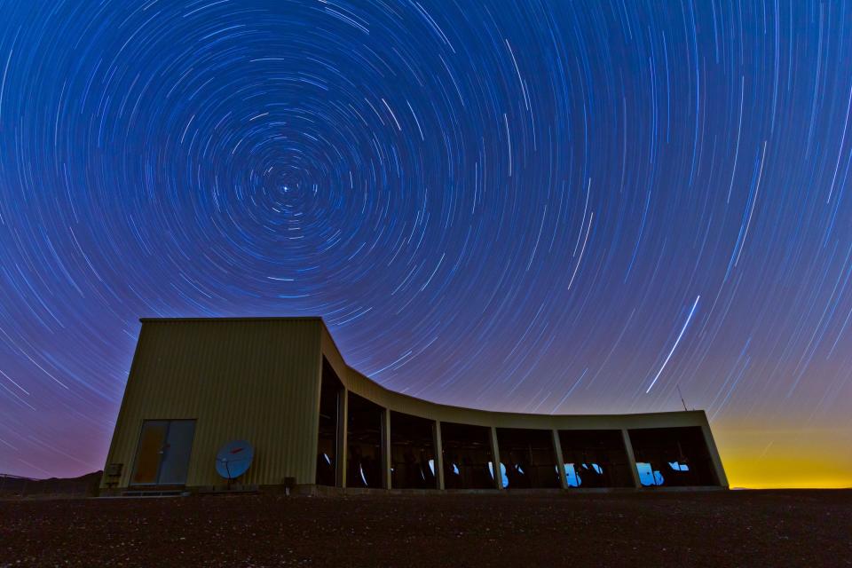 In this time-lapse photo, stars appear to rotate above the Middle Drum facility of the Telescope Array, a $25 million cosmic ray observatory that sprawls across the desert west of Delta, Utah. Physicists from the University of Utah, University of Tokyo and elsewhere report the observatory has detected a “hotspot” in the northern sky emitting a disproportionate number of ultrahigh-energy cosmic rays, which are the most energetic particles in the universe.