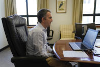 In this image provided by the Office of the Governor of Virginia, Virginia Gov. Ralph Northam as he participates in a Skype interview from his office at the Capitol in Richmond, Va., Thursday April 2, 2020. (Jack Mayer/Office of the Governor of Virginia via AP)