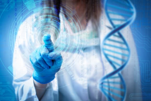 A lab worker pointing at a touchscreen in the plane of the image, a strand of DNA is displayed to the right.