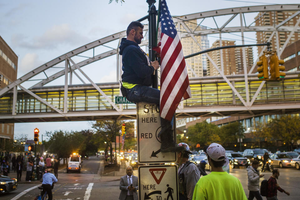 <p>A man places a U.S. flag in memory of the victims of the recent truck attack on the bike path near the crime scene Thursday, Nov. 2, 2017, in New York. (Photo: Andres Kudacki/AP) </p>