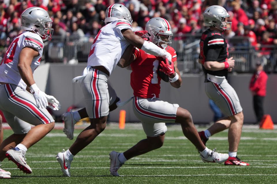 Apr 13, 2024; Columbus, OH, USA; Ohio State Buckeyes running back Quinshon Judkins (1) carries the ball while being tackled by Ohio State Buckeyes safety Caleb Downs (2) during the Ohio State football spring game at Ohio Stadium.