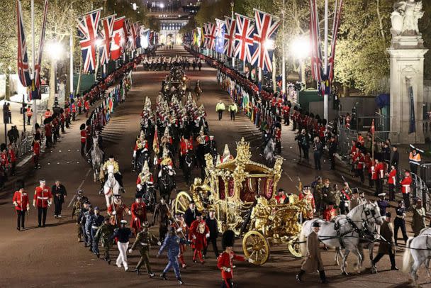 PHOTO: The Gold State Coach is accompanied by members of the military during a full overnight dress rehearsal ahead of the coronation for King Charles and Camilla, Queen Consort, in London, May 3, 2023. (Henry Nicholls/Reuters)