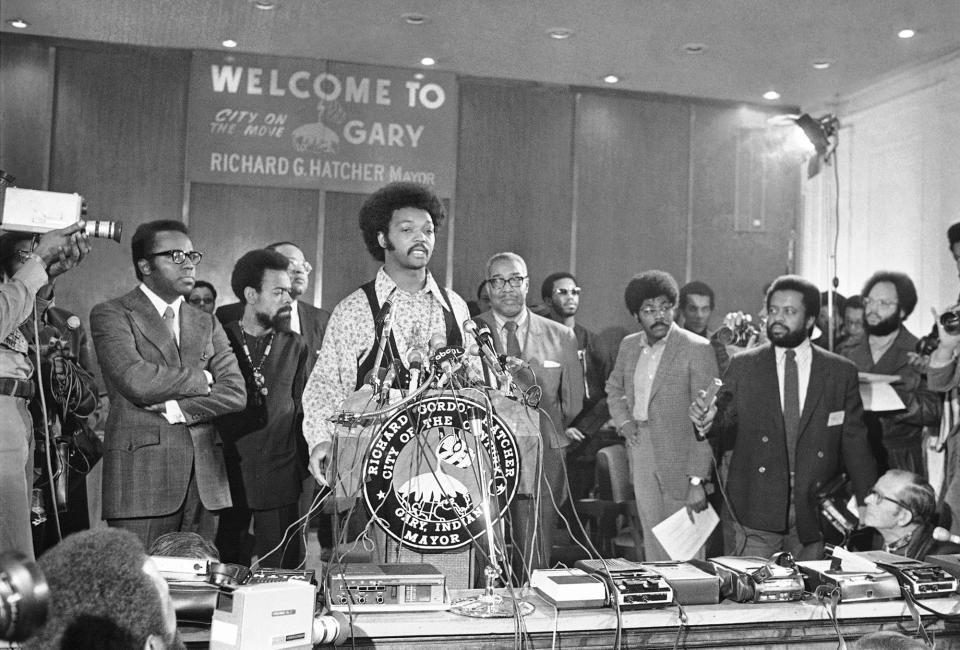 The Rev. Jesse Jackson talks to the media at the convention as Gary Mayor Richard G. Hatcher and writer-activist Amiri  Baraka look on.