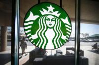 A Starbucks logo hangs on a window at a newly designed Starbucks coffee shop in Fountain Valley, California August 22, 2013. REUTERS/Mike Blake