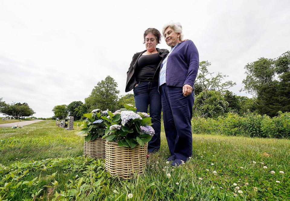 Kara Guerriero, left, and her mother, Judy Sweeney, stand at the grave of Rafe Sweeney, Kara's brother and Judy's son, at St. Columba Cemetery in Middletown.