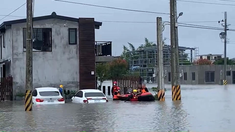 宜蘭縣今天降下滂沱大雨，宜蘭市清華2路一帶成了水鄉澤國，水深及腰，8名入住民宿的旅客被大水困住，消防出動橡皮艇救援，協助8名旅客撤離。（讀者提供）