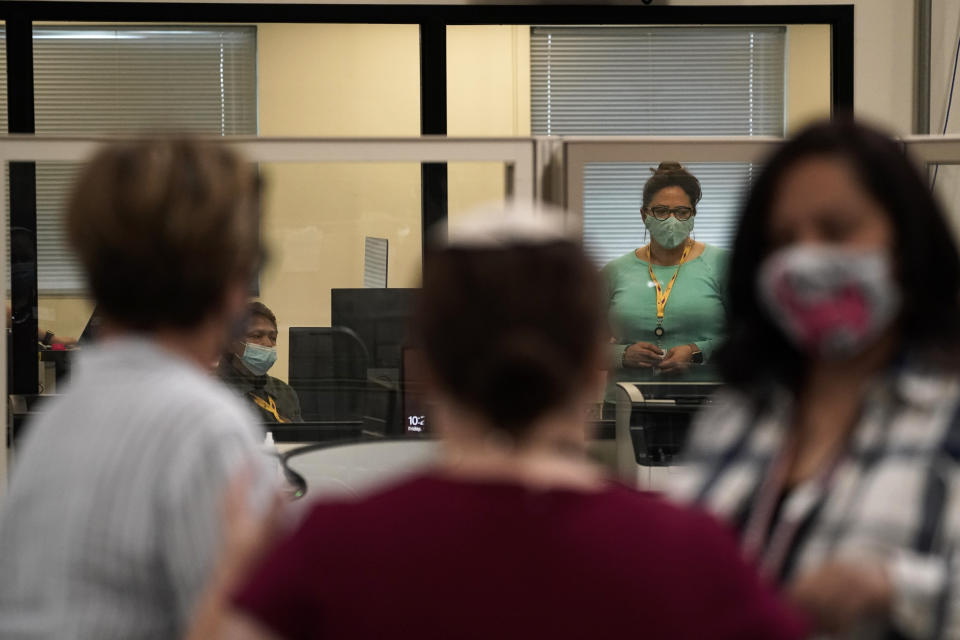 Observers, in foreground, chat as election workers work in a tabulation room at the Clark County Election Department in North Las Vegas, Friday, Nov. 6, 2020. (AP Photo/Jae C. Hong)