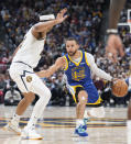 Golden State Warriors guard Stephen Curry, right, drives past Denver Nuggets forward Zeke Nnaji in the second half of an NBA basketball game Thursday, Feb. 2, 2023, in Denver. (AP Photo/David Zalubowski)