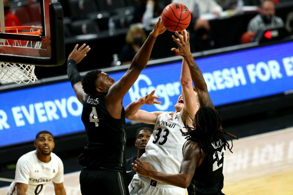 Cincinnati Bearcats center Chris Vogt (33) has his shot blocked by UCF Knights forward Jamille Reynolds (4) in the second half of an NCAA men's college basketball game, Sunday, Feb. 14, at Fifth Third Arena in Cincinnati. The Cincinnati Bearcats won, 69-68. Reynolds was with UCF prior to Temple. He is now a UC Bearcat.