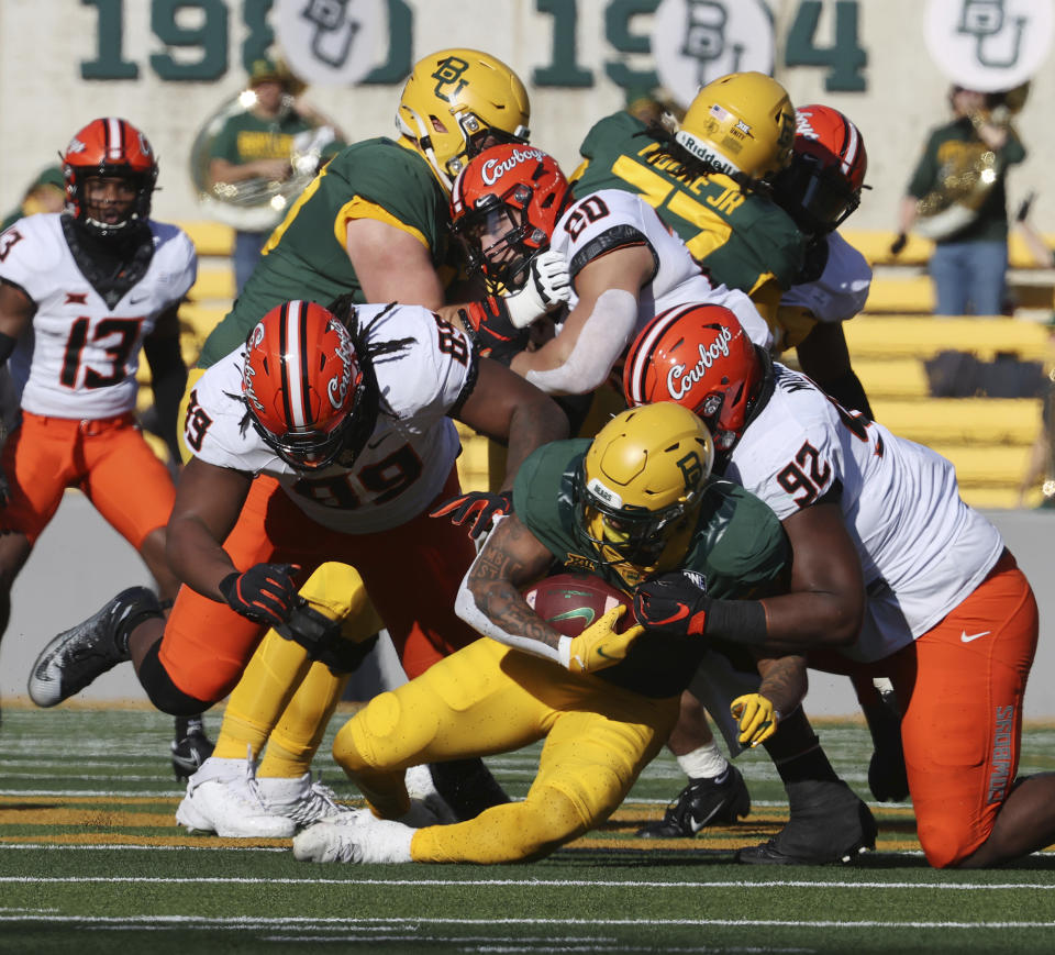 Oklahoma State defensive tackle Cameron Murray, right, tackles Baylor running back Trestan Ebner in the first half of an NCAA college football game, Saturday, Dec. 12, 2020, in Waco, Texas. (Rod Aydelotte/Waco Tribune-Herald via AP)