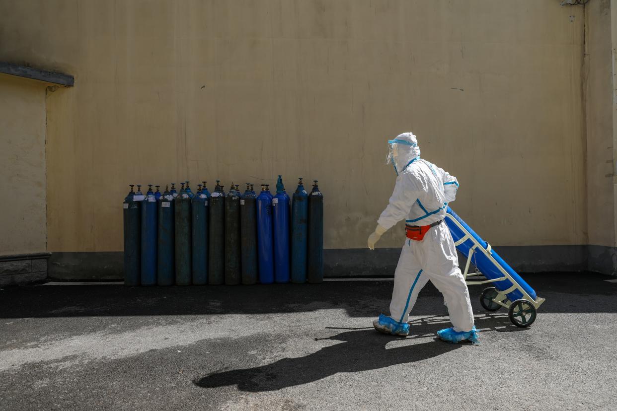 FILE PHOTO: A medical worker in protective suit transports an oxygen tank at Wuhan Red Cross Hospital in Wuhan, the epicentre of the novel coronavirus outbreak, in Hubei province, China February 16, 2020. Picture taken February 16, 2020. China Daily via REUTERS  