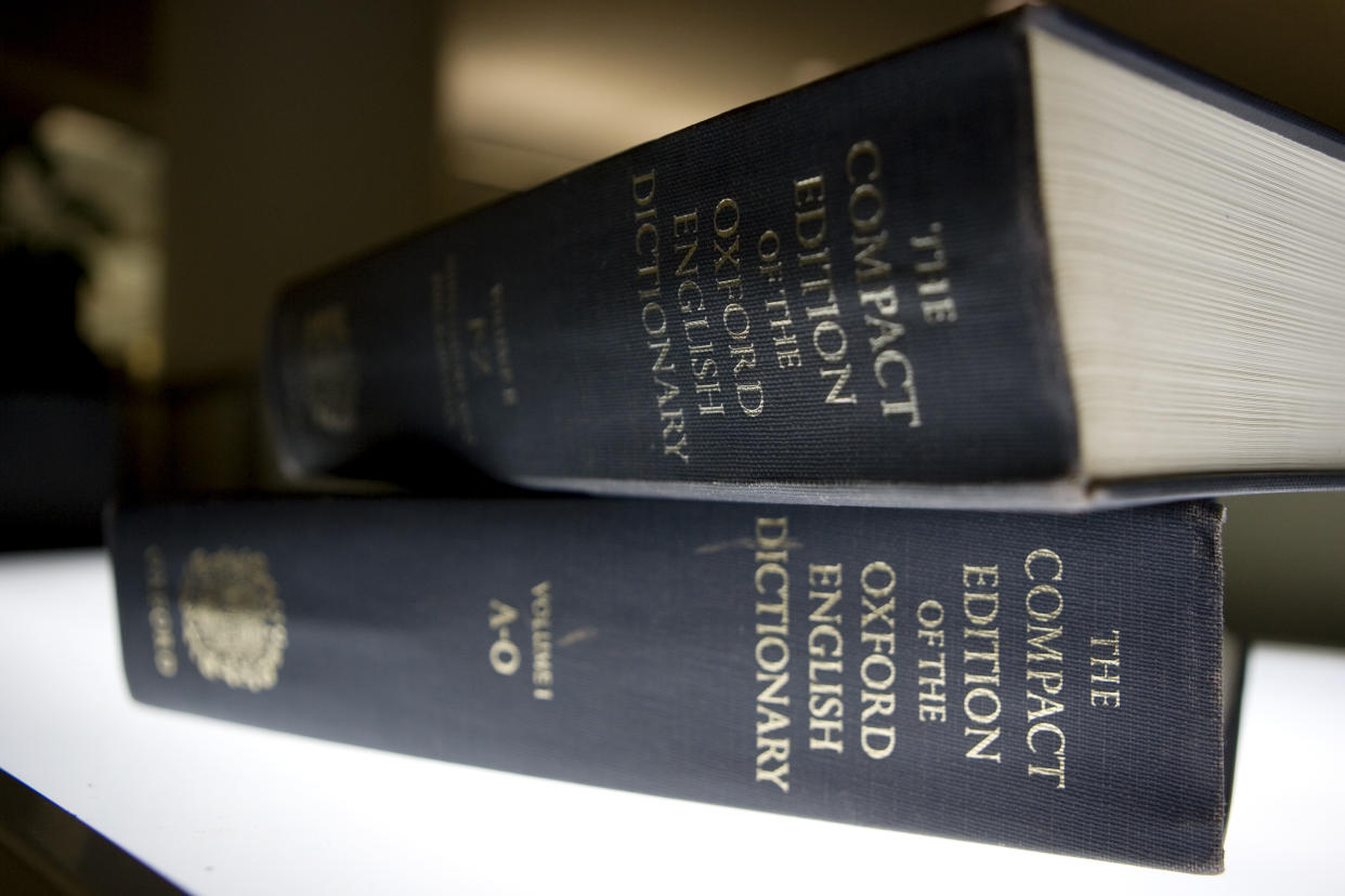 Two stacked copies of the Oxford English Dictionary on a table.