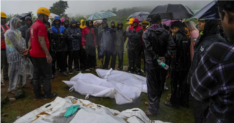 救難人員冒著大雨搜救，至少已發現多具罹難者屍體。（圖／達志／美聯社）