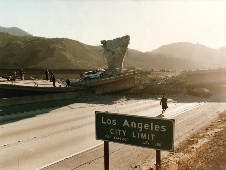 LOS ANGELES - JAN 17, 1994 - City of Los Angeles sign in the foreground of the Interstate 5 southbound lanes where the Interstate 14 road fell. The motorcycle and body of deceased LAPD officer Dean is seen at left. (Steve Dykes / Los Angeles Times)